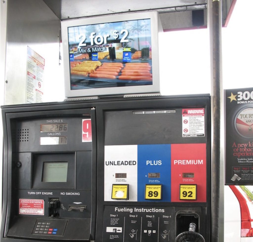 Close-up of gas pump with an ad above